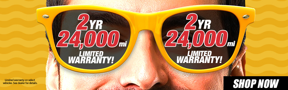 Close-up of a face wearing yellow sunglasses with text on the lenses reading 
